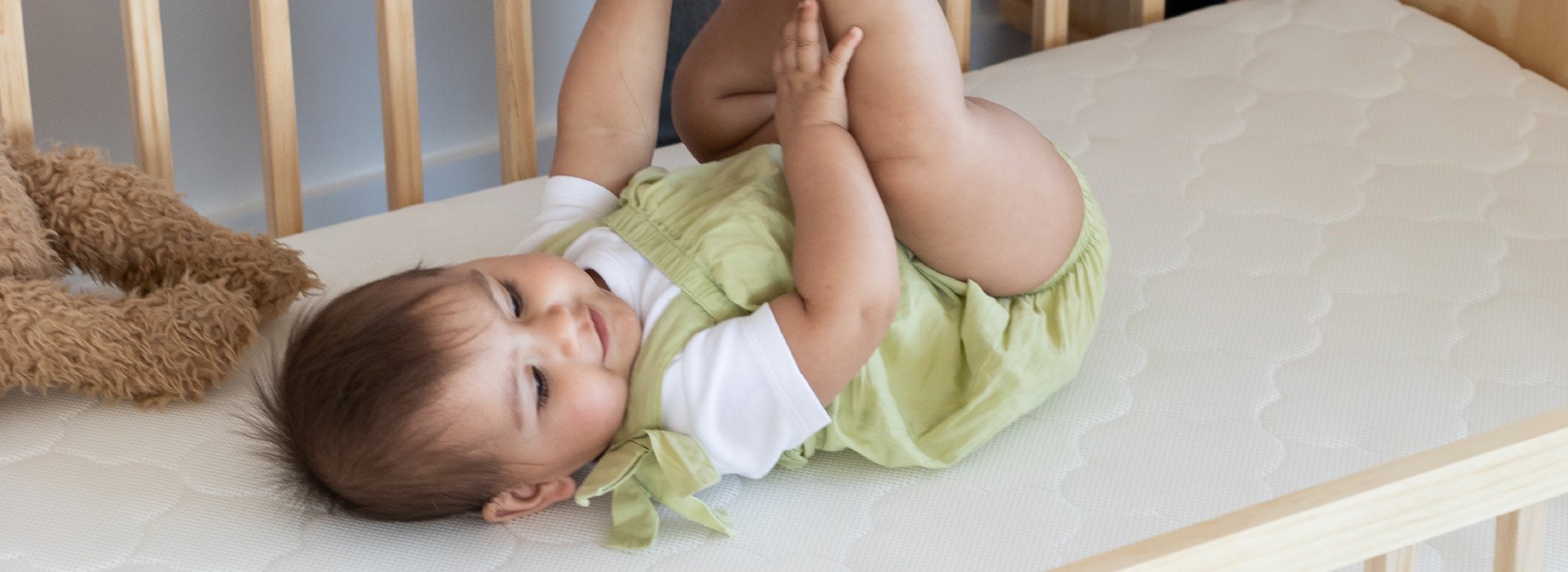 A baby lying atop a Fullair cot mattress.	